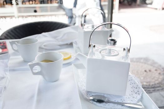 tea break with a white tea set at a table in a cafe in the city, High quality photo