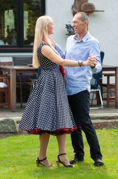 beautiful young couple of newlyweds dancing tango on the lawn in the garden. High quality photo