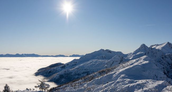 Winter mountains covered with snow landscape over clouds. High quality photo