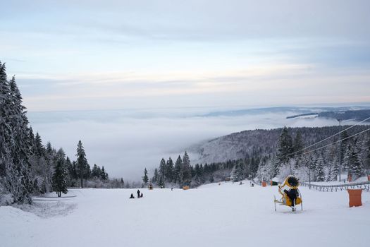 magnificent winter landscape on Wasserkuppe mountain in Ren, Hesse, Germany. magical tall and large pines and snowy firs covered with snow and ice. The horizon creates an illusion and merges with the cloudy sky and fog, which covers all the space visible in the distance. High quality photo