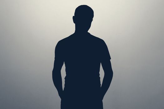 Unknown male person silhouette in studio. Concept of anonymous or hidden secret.