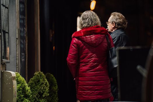 Photo of two people retired man woman meeting talking after dinner night street illumination fair outside