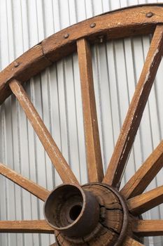 Antique wooden wheel on metallic background close up