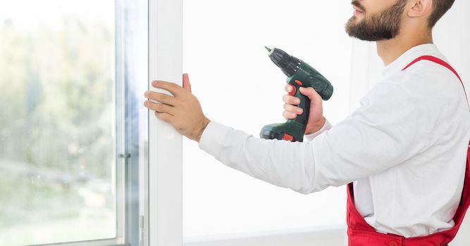 Close up of a mans hand holding screwdriver machine.