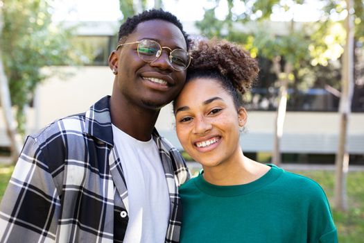Portrait of happy African American young couple outdoors in nature looking at camera. Relationship concept.