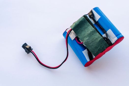 a broken lithium battery pack with wires and a terminal. power supply of modern household appliances. Packaging of lithium-ion batteries in a blue plastic shell. copy space. battery for robot vacuum cleaner