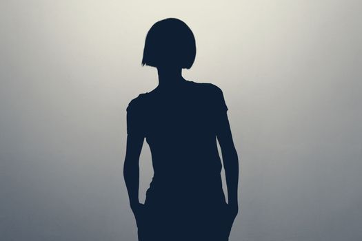 Unknown female person silhouette in studio. Anonym unrecognizable woman. Hiding identity