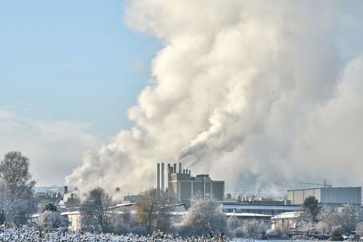 Environmental problem of pollution of environment and air in cities. Smoking industrial zone factory chimneys. View of large plant with Smoking pipes Smoke from the paper industry, which is running every day of the year. Photo taken December 2022 Air pollution in the city. Smoke from the chimney on blue sky background. High quality photo