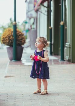 beautiful baby girl in dress on the street.