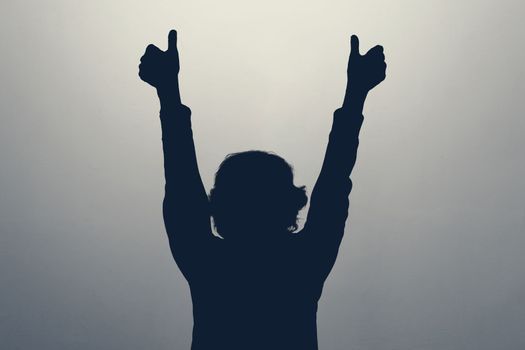 Unknown female person silhouette in studio showing thumb up approving your choice