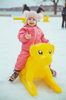 Beautiful baby riding on a sled in the rink in Denmark.