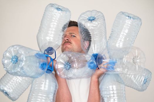 Caucasian man holding empty plastic bottles for water. Pure water crisis concept.