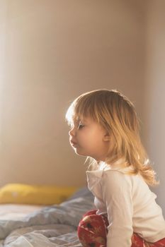 charming beautiful baby sitting on the bed.