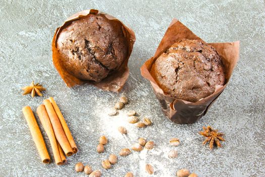 Homemade delicious chocolate cupcake muffin on a light gray stone background with spices