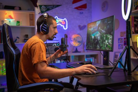 Professional Gamer Streaming and Playing Online Video Game on Computer Colorful Neon Led Lights. High quality photo