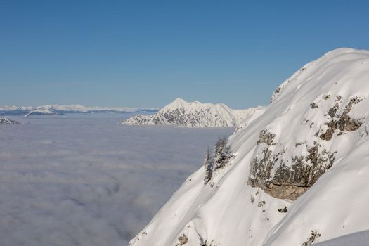 Winter mountains covered with snow landscape over clouds. High quality photo