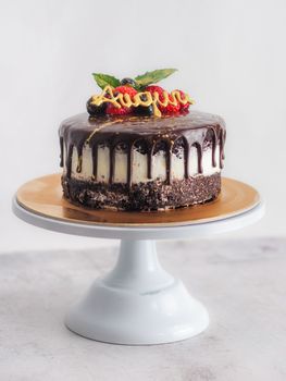 dark chocolate drips birthday sweet cake, fresh fruits Raspberry strawberry blueberry cranberry on top, decorated with golden edible paint