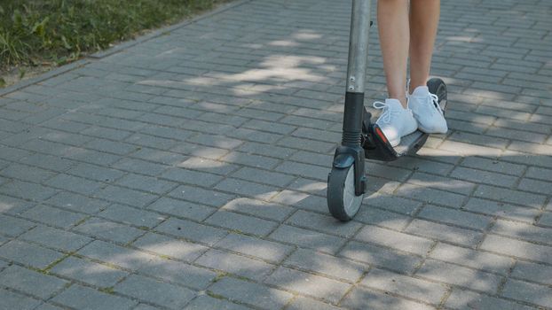 A girl rolls around on city tiles in the park