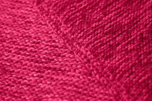 Viva Magenta toned colour monochrome texture knitted fabric. Dark pink knitted Jersey as textile background. Monochrome color background. Trendy color 2023.