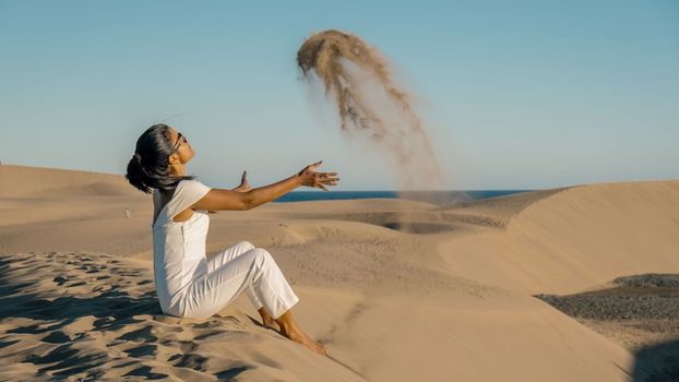 woman walking at the beach of Maspalomas Gran Canaria Spain, a girl at the sand dunes desert of Maspalomas Spain Europe