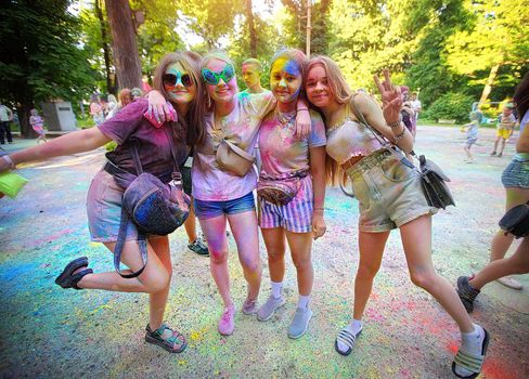 Young people, teenagers and adults celebrate the Holi event in Ukraine in Chernivtsi on March 8 in 2022. They have fun and throw paint at each other. High quality photo
