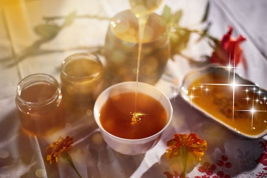 a jar of sweet honey on a table from a garden with apples in a bowl drips from a brush from a spoon a glass jar with cheese and roses and fresh bread with bright light beautiful decoration creative photo in a bucket on a wooden table in a garden with flowers for breakfast delicious food. High quality photo