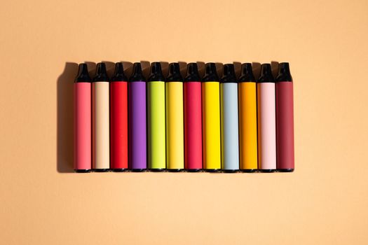 Assortment of disposable e-cigarettes on a light background. Nicotine vapor system, top vew