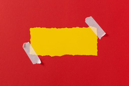 Black friday concept. Top view of yellow torn paper sheet and black friday text on red background. Composition Black Friday. Vivid colors.