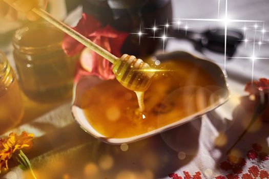 a jar of sweet honey on a table from the garden with apples in a glass