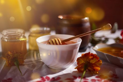 a jar of sweet honey on a table from the garden with apples in a glass