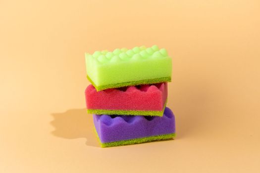 Stack of many multi-colored dish wash sponges isolated on white background. Household cleaning scrub pad.