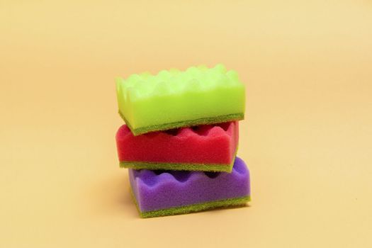 Stack of many multi-colored dish wash sponges isolated on white background. Household cleaning scrub pad.