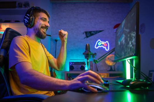 Professional Gamer winning and celebrating victory Online Video Game on Computer side view. High quality photo