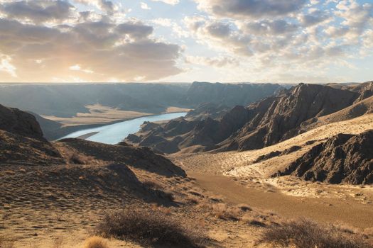 View from afar of the river in the arid steppe of Kazakhstan Ili, Almaty region, Central asian nature scenery landscape.