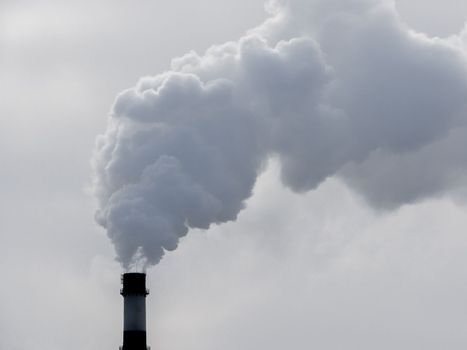 industrial chimneys with heavy smoke causing air pollution on gray sky background. Dyrty smoke