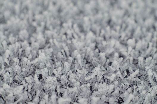 Textured winter background made of crystals. A lot of small pieces of ice. Frozen water. Macro photography. A natural phenomenon.