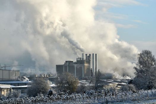 Environmental problem of pollution of environment and air in cities. Smoking industrial zone factory chimneys. View of large plant with Smoking pipes Smoke from the paper industry, which is running every day of the year. Photo taken December 2022 Air pollution in the city. Smoke from the chimney on blue sky background. High quality photo