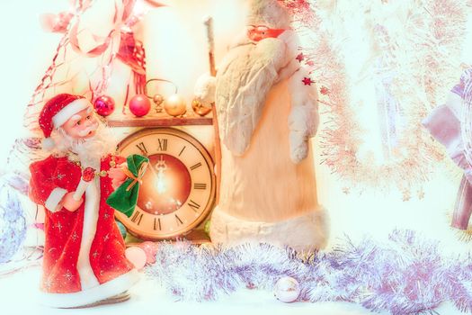 the annual Christian festival celebrating Christ's birth, held on December 25 in the Western Church. Two Santa Claus and vintage clock in bright golden silver Christmas New Year lights