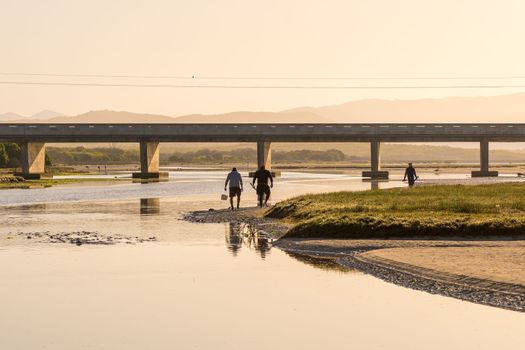 Sunrise view of the lagoon at Uilenkraalsmond at Franskraalstrand near Gansbaai in the Western Cape Province. The bridge on road R43 over the river and bait collectors are visible