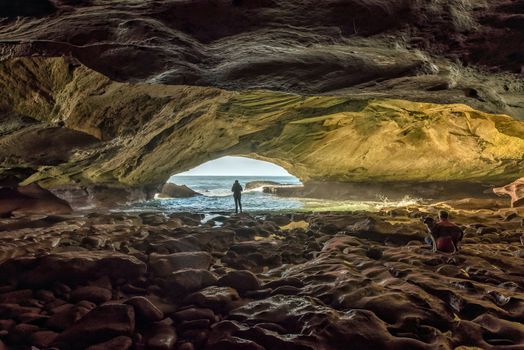 Inside the Waenhuiskrans Cave near Arniston in the Western Cape Province. People and a dog are visible