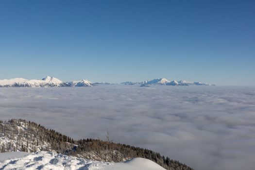 Winter mountains covered with snow landscape over clouds. High quality photo