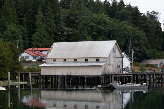 Fishboat wharf and shed with reflection in water at Sointula, Malcolm Island, British Columbia, Canada