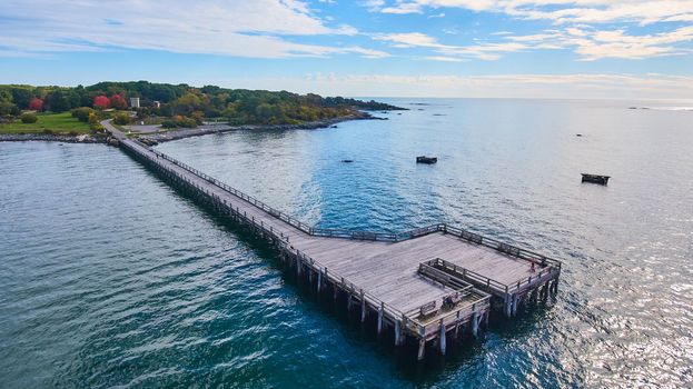 Image of Aerial over large walking pier for tourists attached to Maine coast