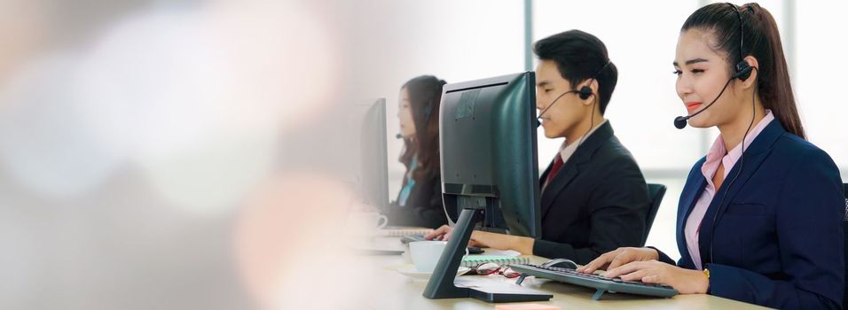 Business people wearing headset working in office in widen view to support remote customer or colleague. Call center, telemarketing, customer support agent provide service on telephone video call.