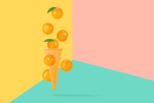 Falling ice cream cone with mandarin fruits. Seven flying whole tangerines on colored table with clipping path as package design element and advertising. Full depth of field.