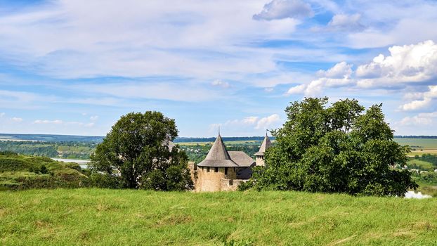 a military stronghold, especially a strongly fortified town fit for a large garrison. Old medieval fortress museum on green hills by the river