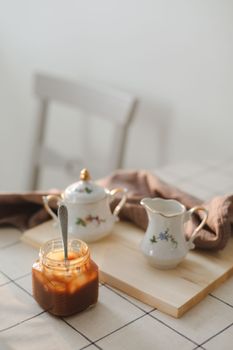 Homemade salted caramel sauce in jar on rustic wooden table