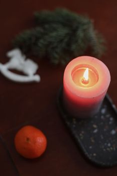 Christmas Toy horse, candle, tangerines and pine cone. Winter holiday items for home decor. Flat lay stock photography.