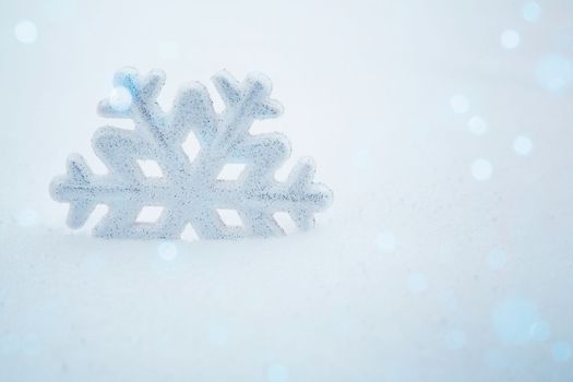 A snowflake in the snow. Christmas background with decorative snowflake on snow. Christmas decoration. Winter holiday concept