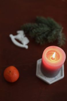 Christmas Toy horse, candle, tangerines and pine cone. Winter holiday items for home decor. Flat lay stock photography.